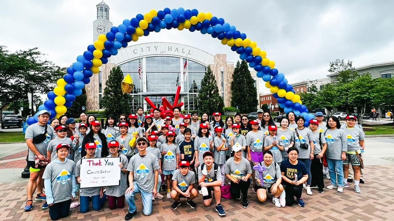 A large First Step team posing beneath the CFF event arch