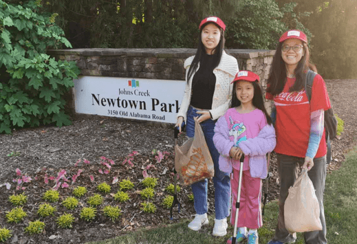 Young volunteers holding orange cleanup bags on Earth Day
