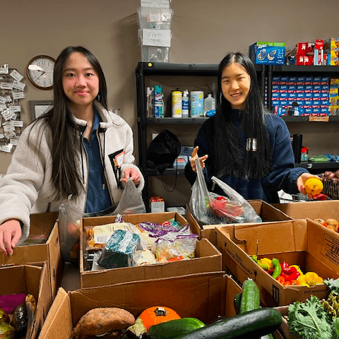 Two volunteers organizing produce and pantry donations