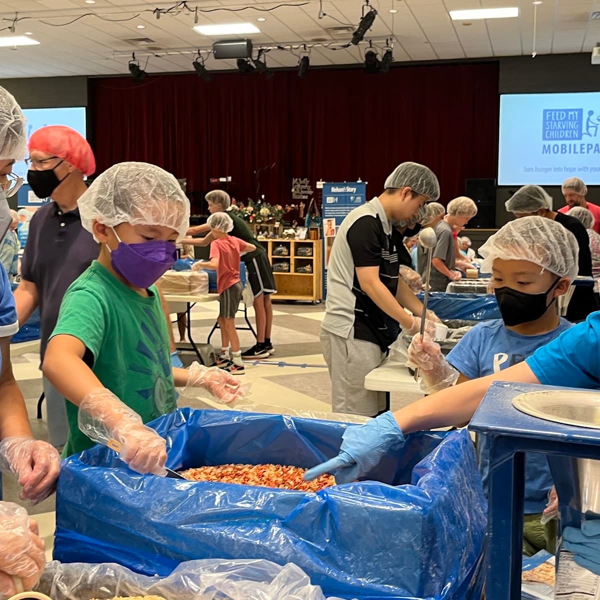 Volunteers sorting donated food at a warehouse table