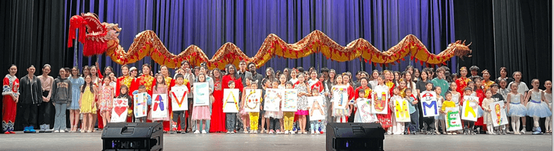 A large group of youth performers standing across a charity event stage