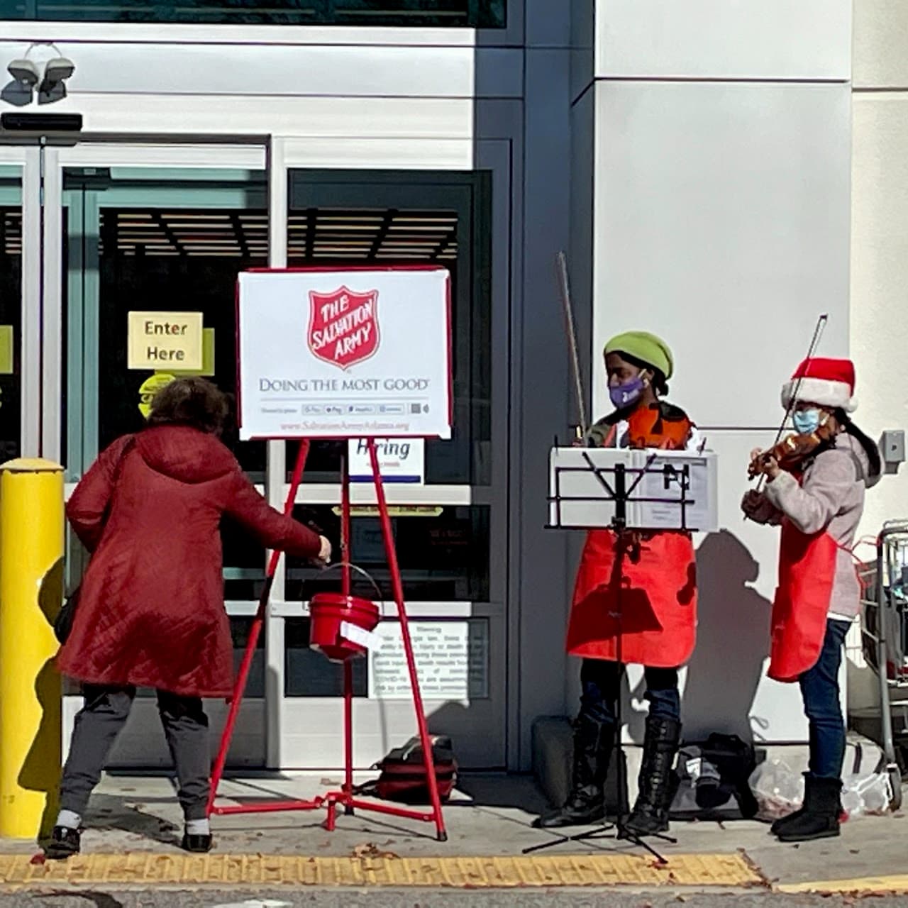 First Step musicians performing beside a Salvation Army kettle stand