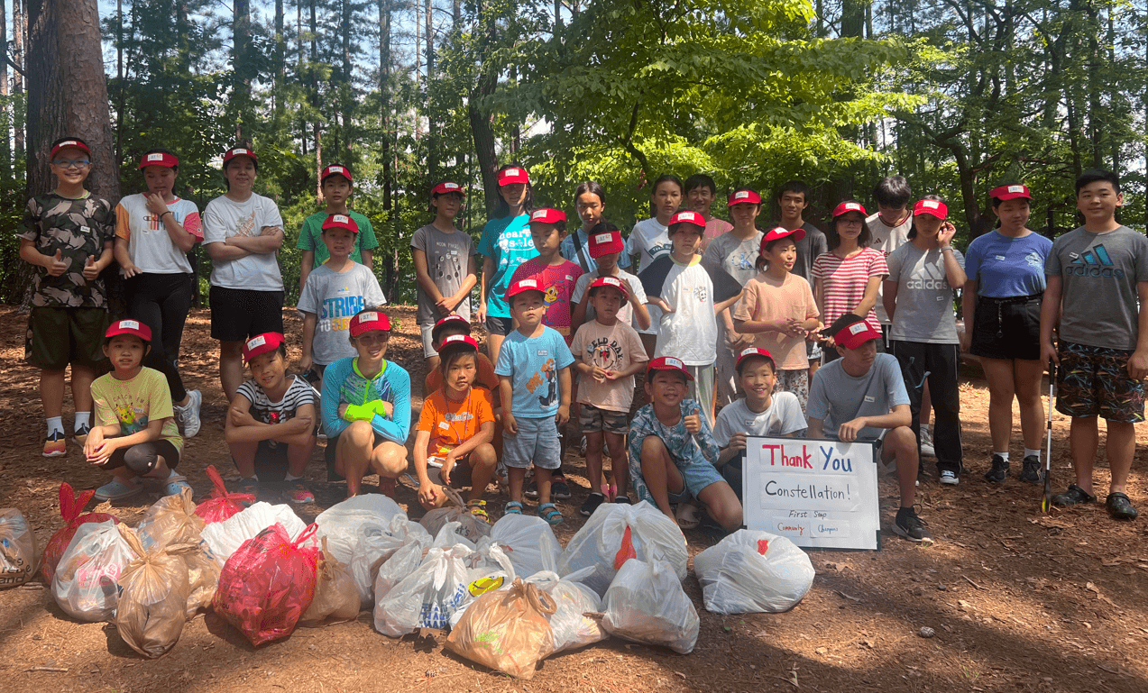 A large volunteer group with bags of litter after a West Bank cleanup